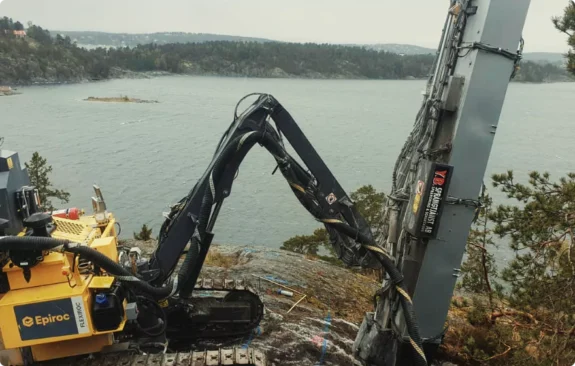 Bergspräckning Stockholm med borrigg på svårtillgänglig bergshäll vid vattennära miljö.